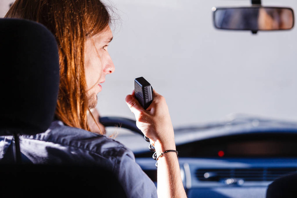 Hablando mientras conduces, walkie talkie automático, concepto de comunicación. Joven conduciendo coche usando radio cb
 - Foto, Imagen
