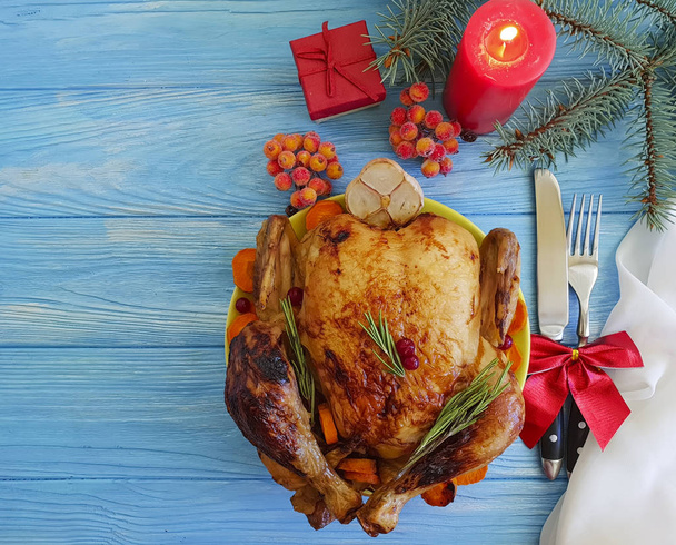 pollo intero fritto, ramo di un albero di Natale su uno sfondo di legno blu
 - Foto, immagini