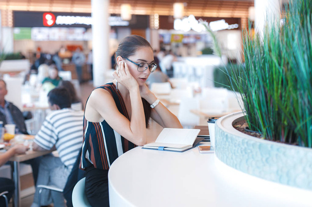 Menina atraente jovem em óculos no café. Estilo de vida retrato de negócios
 - Foto, Imagem