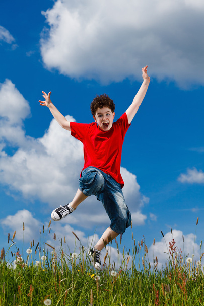 Boy jumping, running against blue sky - Фото, зображення