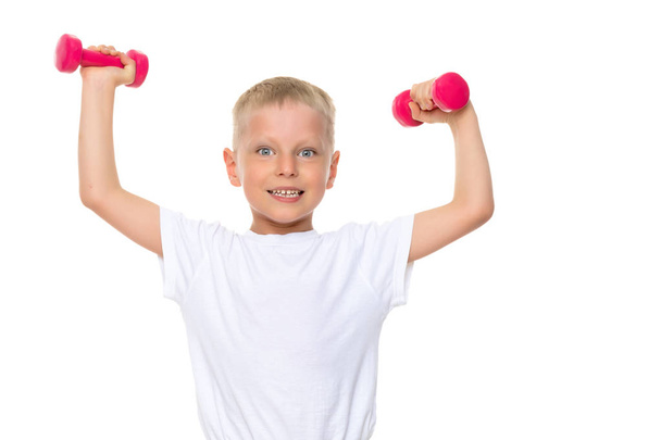 A little boy is lifting dumbbells. - Foto, Bild