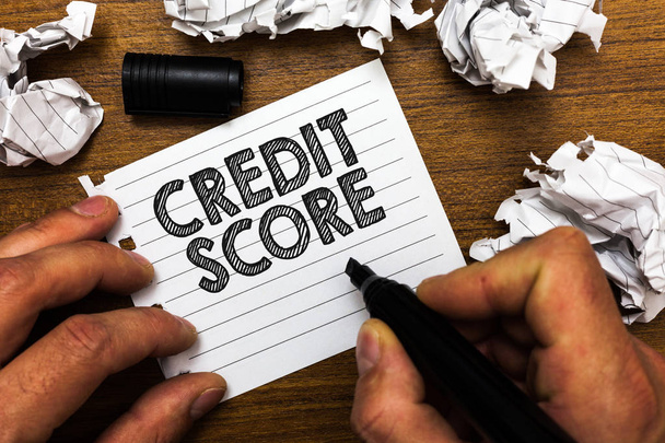 Text sign showing Credit Score. Conceptual photo Represent the creditworthiness of an individual Lenders rating Man holding marker notebook page crumpled papers several tries mistakes - Фото, изображение