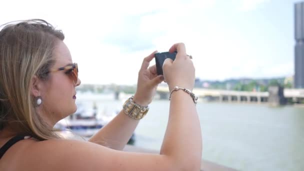 Beautiful brunette tourist films a city with her smartphone - ALT - Materiał filmowy, wideo