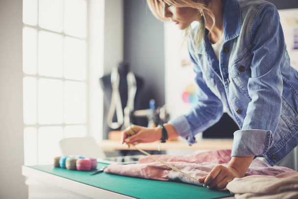 Fashion designer woman working on her designs in the studio - Фото, изображение