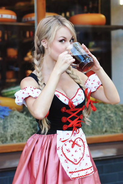 Bella donna beve birra in abito Octoberfest
.  - Foto, immagini