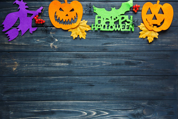 Halloween decor: leaves, rowan, pumpkins, banners on the wooden background. Halloween decorations. Flat lay, copyspace, top view - 写真・画像