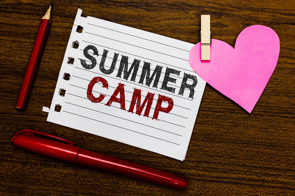Word writing text Summer Camp. Business concept for Supervised program for kids and teenagers during summertime. Notebook piece paper markers clothespin holding heart wooden background - Photo, Image