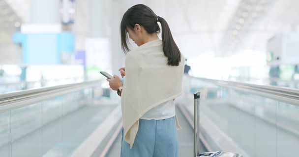 Woman using mobile phone in the airport - Foto, afbeelding