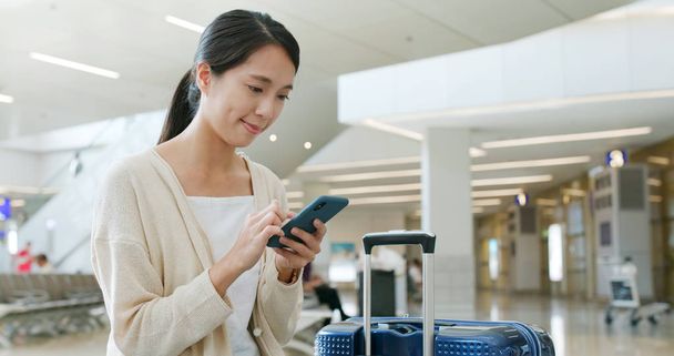 Donna che utilizza il telefono cellulare in aeroporto
 - Foto, immagini