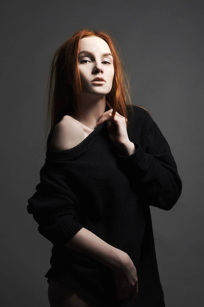 emotion portrait. sexy Beautiful young ginger woman in black. red hair girl with make-up posing in studio - Foto, Imagen