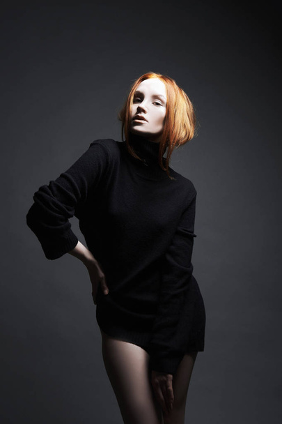 fashion portrait of sexy Beautiful young ginger woman in black. red hair girl with make-up posing in studio - Фото, зображення
