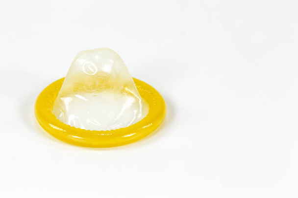 un preservativo parzialmente arrotolato a sinistra isolato su fondo bianco
 - Foto, immagini