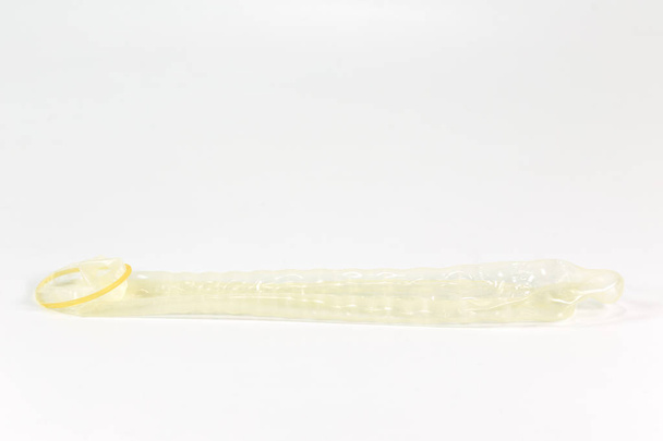 Soldaki beyaz arka plan üzerinde izole kapalı haddelenmiş prezervatif - Fotoğraf, Görsel