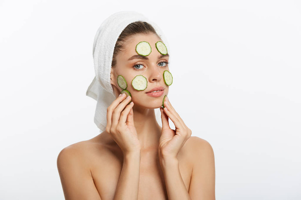 Surprised woman looks after the skin with cucumber - Foto, Imagem