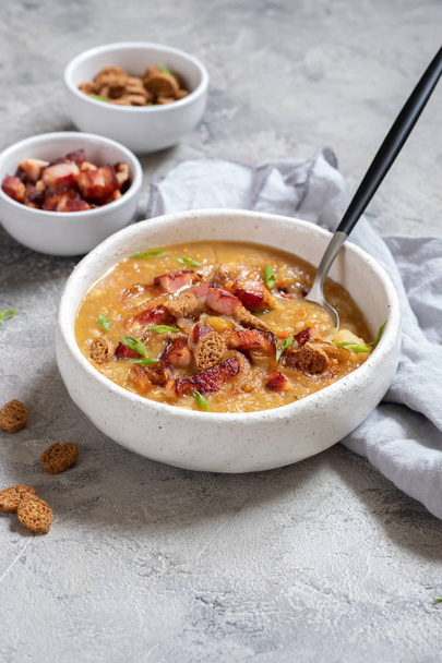Lentil pea soup garnish with bacon, onion and croutons. - 写真・画像