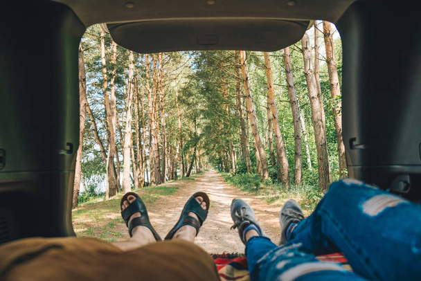 couple laying in suv trunk looking on forest. first person point of view - Fotoğraf, Görsel