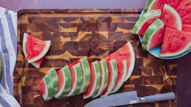 Slicing red watermelon on a wood cutting board.  - Fotoğraf, Görsel
