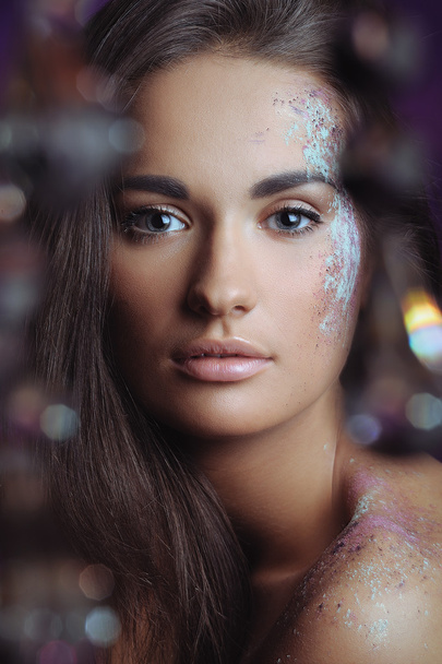 Beautiful woman with festive makeup in color spray and boke lights - 写真・画像