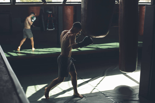 Sportsman is having intensive combat training in club - Фото, изображение