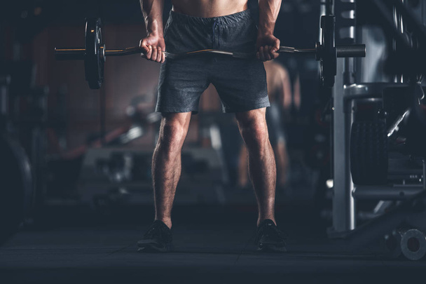 Bodybuilder is lifting barbell in sport club - Φωτογραφία, εικόνα