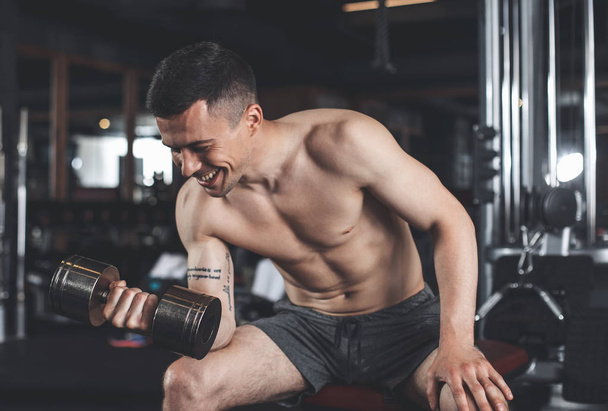 Joyful man is enjoying upper body workout indoors - Fotografie, Obrázek