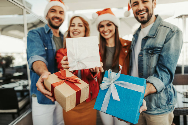 Cheerful company holding presents wrapped in lovely packages - Foto, Imagen