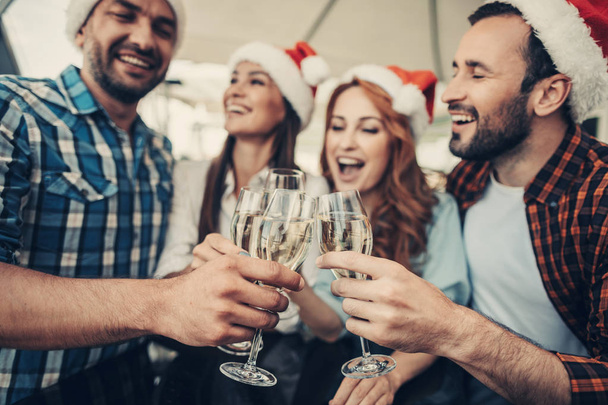 Cheerful friends raising glasses of champagne to meet New Year - Foto, Bild