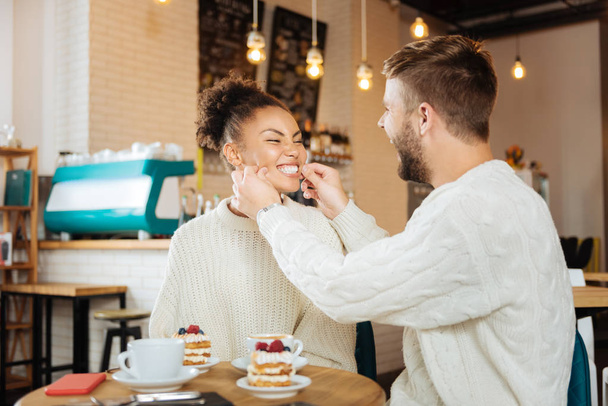 Cute couple wearing the same sweaters eating delicious desserts - Fotó, kép