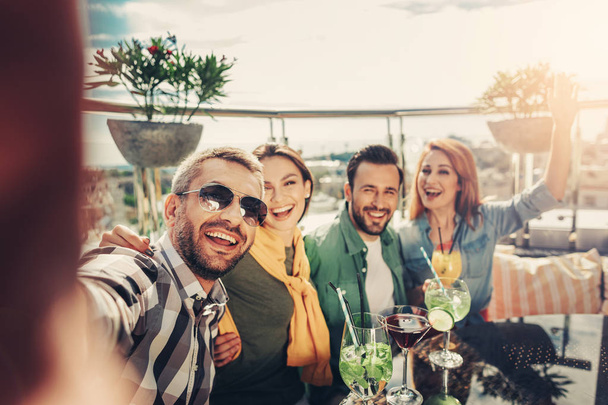 Cheerful friends making selfie at rooftop bar - Fotoğraf, Görsel