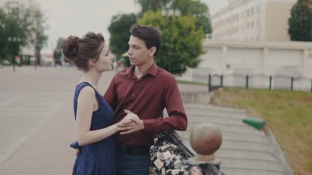 Young couple embrace each other on city street. Handsome man and woman hugging - Materiał filmowy, wideo