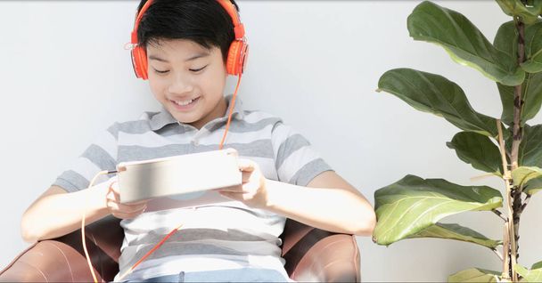 asiatique pré adolescents jouer tablette ordinateur avec sourire visage à la maison
. - Photo, image