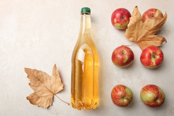 Apple cider in fles en appels op neutrale achtergrond. Bovenaanzicht. Concept alcoholische drank. - Foto, afbeelding