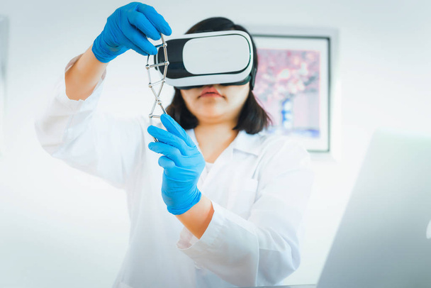 Portret van vrouw wetenschapper is onderzoek Dna cel model met haar bril., wetenschap en onderzoek-concept van virtuele realiteit. - Foto, afbeelding