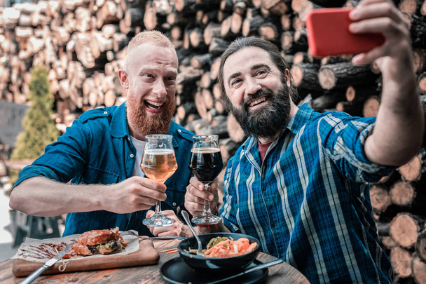 Two best friends making selfie while drinking beer together - Fotoğraf, Görsel