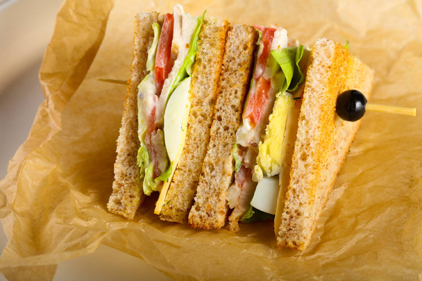 Sándwich club con carne, queso y verduras
 - Foto, imagen