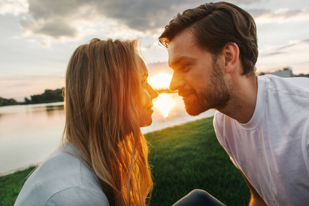 Happy girlfriend telling with beaming man outside - Foto, Imagem