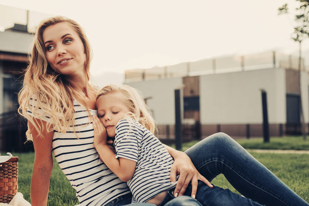 Glad woman with calm daughter relaxing outdoor - Foto, Imagem