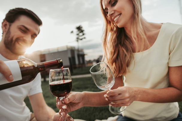 Optimistic man and woman drinking wine outdoor - Foto, imagen
