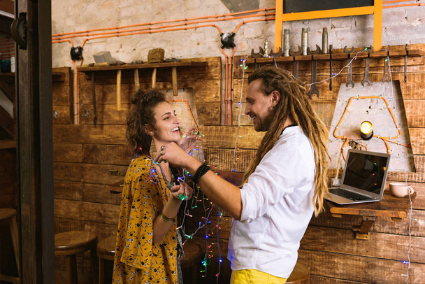 Two flower children having fun while decorating building - Фото, изображение