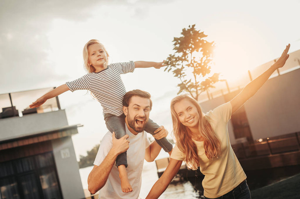 Glad family flourishing rms during fun outside - Фото, изображение