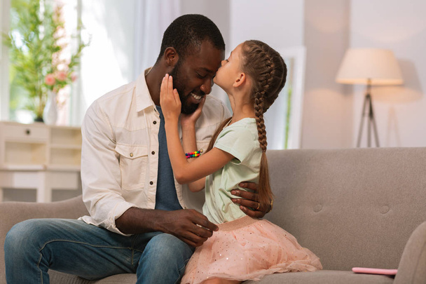 Menina bonita agradável beijando seu pai em casa
 - Foto, Imagem