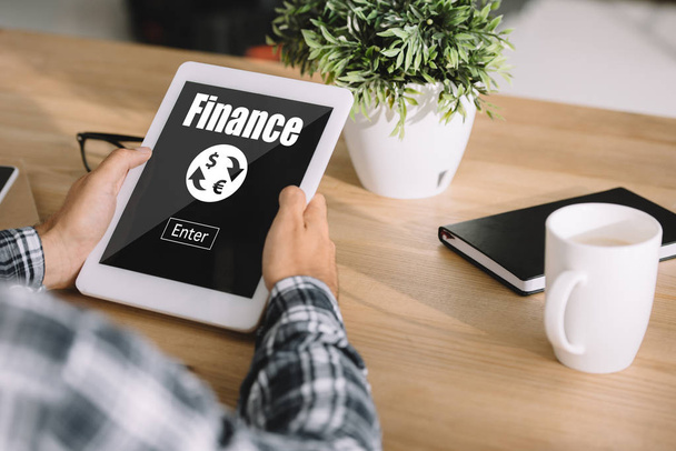 cropped shot of man in plaid shirt using tablet with "finance" lettering - Photo, Image