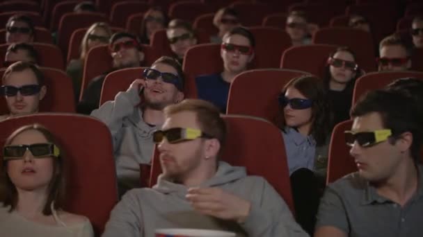 Ember beszél telefonon, cinema hall-ban. Iskolázatlan ember zavarja az emberek film színház. Az ember bánt az emberek nézni 3D-s film a moziban. Talán műveletleneknek modor moziban - Felvétel, videó