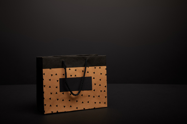close up view of paper shopping bag on black backdrop - Foto, Bild