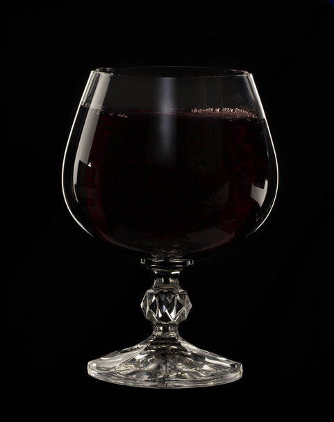 Natürmort resim A cam siyah bir zemin üzerine bir bardak kırmızı şarap yakın çekim - Fotoğraf, Görsel