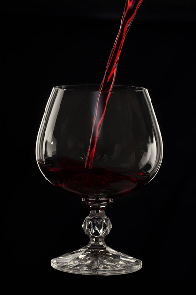 Verre nature morte image Un verre de vin rouge dans un verre sur un fond noir gros plan
 - Photo, image