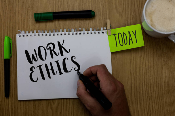 Writing note showing Work Ethics. Business photo showcasing A set of values centered on the importance of doing work Man holding marker notebook clothepin reminder wooden table cup coffee - Photo, Image