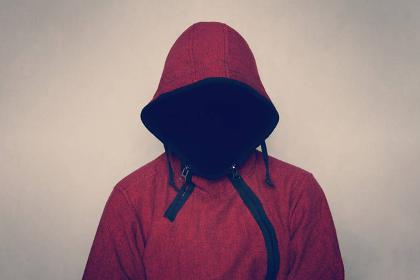 Απρόσωπη άγνωστες και αγνώριστος ο άνθρωπος χωρίς ταυτότητα φορώντας κουκούλα σε σκοτεινό δωμάτιο, τρομακτικό πρόσωπο ποινικές. - Φωτογραφία, εικόνα