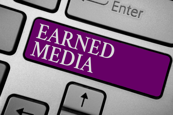 Writing note showing Earned Media. Business photo showcasing Publicity gained through promotional efforts by multimedia Keyboard purple key Intention computer computing reflection document - Photo, Image