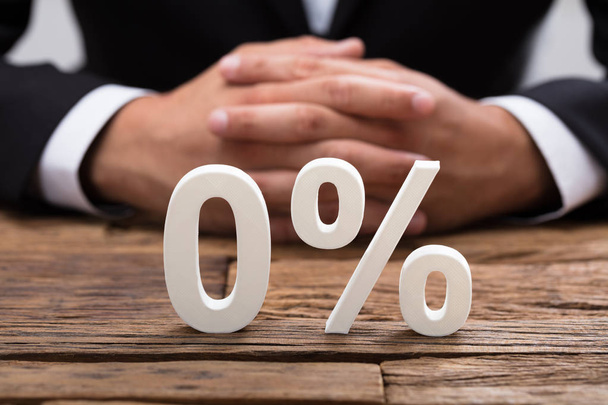 White zero percentage symbol in front of businessperson's hand - Foto, Imagem